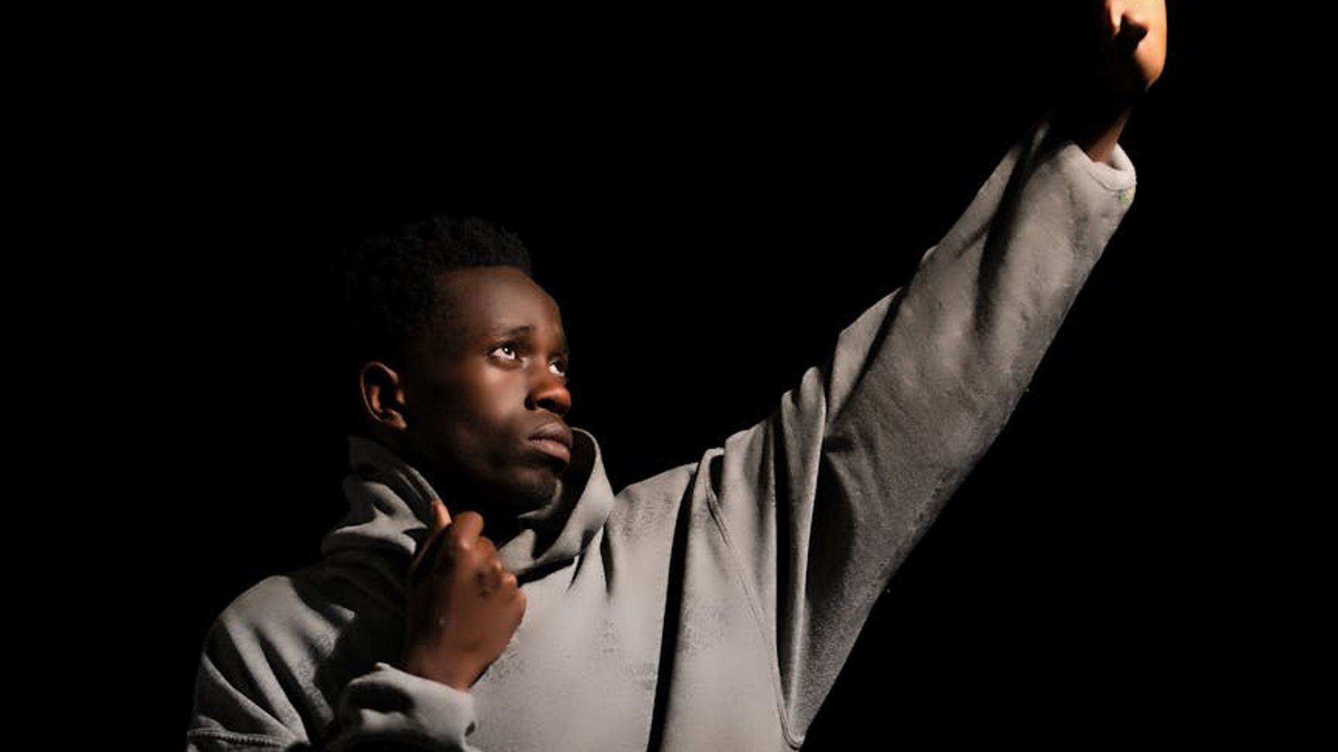 Silhouette of a person in a dynamic pose against a dark background.
